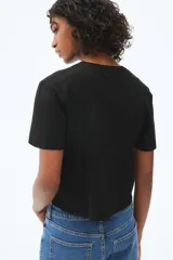 Remera negra de punto fino, con cuello redondo y mangas cortas.