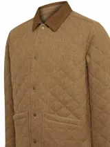 Chaqueta acolchada gris con patrón de rombos, cuello de pana marrón, cierre con broches metálicos, bolsillos frontales y bolsillo interno.