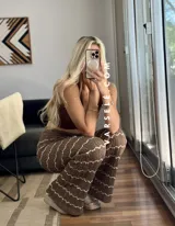 Pantalón de hilo color marrón con rayas horizontales blancas, corte holgado y cintura con cordón ajustable.