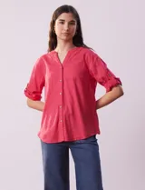 Blusa color rosa de lino marca Cupio, con cuello a la base, escote en V y abertura con botones. Tiene un bolsillo en la parte delantera y mangas 3/4 regulables con presilla y botón.