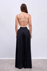 Pantalón palazzo plisado color azul marino, de tiro alto con bolsillos laterales y cierre frontal con botón.