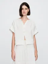 Camisa de muselina color blanco, con cuello mao y mangas cortas.
