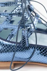 Botines semi-abiertos de cuero azul con diseño calado, cordones con borlas y suela de cuero.