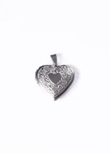 Dije relicario plateado con forma de corazón, con grabado de flores y hojas en el frente y un corazón liso en el centro.