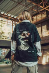 Remerón verde oscuro con efecto stone wash y estampado en la espalda de una escultura con gafas de sol y texto.