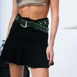 Minifalda de jean celeste con cintura alta, corte recto en la parte superior y falda plisada.