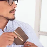 Billetera marrón de símil cuero con banda elástica horizontal beige y blanca. Interior con doble compartimento para billetes, visor y tarjeteros.