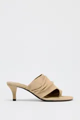 Sandalia tipo mule color beige, de ante, con tacón fino medio y tira ancha con efecto arrugado.