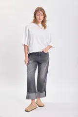 Pantalón jean gris oscuro de corte recto con bajo doblado.
