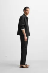 Sobrecamisa negra de algodón con cuello solapa, manga larga con puños abotonados, bolsillos de parche en el pecho y cierre frontal con botones. Corte relaxed fit.
