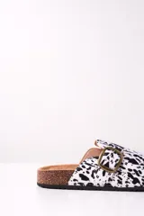 Zueco abierto con estampado animal print blanco y negro, hebilla metálica dorada y plantilla anatómica.