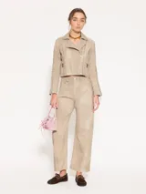 Chaqueta de cuero ovino color beige, con cuello clásico, cierre cruzado y múltiples bolsillos con cierre metálico. Presenta canesú y recortes matelaseados en codos.