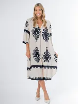 Vestido midi oversized con estampado en fondo negro, cuello tipo camisa, escote en V y tajos laterales.