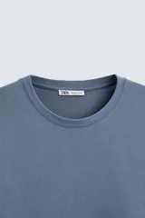 Camiseta color borgoña de corte regular, cuello redondo y mangas cortas.