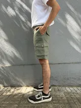 Bermuda de gabardina color marrón claro, corte recto, con bolsillos cargo laterales y bolsillos traseros con solapa.