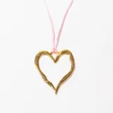 Collar dorado con dije en forma de corazón irregular y cordón fino color rosa.