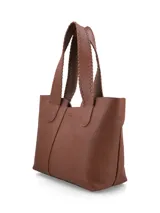 Cartera shopper negra de cuero graneado con panel central de gamuza. Tiene manijas con costuras en cuero y logo metálico de la marca.