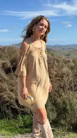 Vestido corto color beige, con escote en V con cordones, mangas 3/4 acampanadas con cordones y hombros descubiertos.