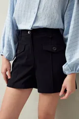 Short blanco de tiro alto con bolsillos delanteros con solapa y botones a la vista.
