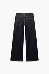 Jeans de tiro bajo con cintura con trabillas, cinco bolsillos, pespuntes marcados a contraste y pierna ancha.