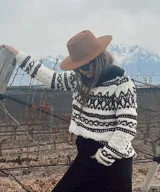 Sweater tejido a mano con lana merino virgen y lana negra, con diseño geométrico en blanco y negro.