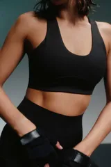 Top deportivo negro con espalda cruzada y abertura triangular.