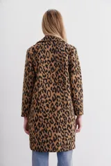 Tapado de paño con estampado animal print, de calce recto y solapas angostas. Tiene botones al frente y bolsillos ojal.