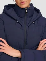 Campera acolchada azul marino de poliéster con cuello con capucha, cierre de cremallera, bolsillos frontales con cremallera y logo Calvin Klein.