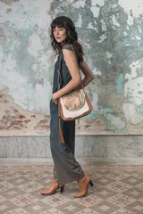 Cartera en cuero 100% vacuno, con manija larga regulable y bolsillos interiores para mayor comodidad.