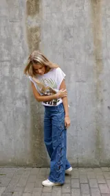 Pantalón de jean azul de tiro medio con diseño trenzado lateral.