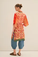 Kimono largo de viscosa con estampado vibrante en tonos rojos, naranjas y amarillos, con detalles en verde. Presenta mangas anchas y un cinturón a juego para ajustar a la cintura.