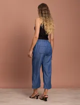 Pantalón capri de jean azul oscuro, con cintura elastizada con cordón ajustable y bolsillos laterales.