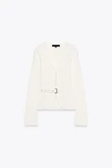 Chaqueta color blanco de punto con escote en pico y manga larga. Cierre frontal con corchetes ocultos y cinturón con hebilla metálica.