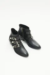 Bota corta de cuero negro con diseño inspirado en el estilo rocker. Presenta tres tiras frontales con remaches y hebillas metálicas color níquel, puntera metálica y taco ancho de 4 cm con detalle de vira metálica. Posee cierre lateral interno.