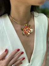 Collar corto con cuello rígido ajustable y medallón en forma de flor bordada con canutillos y cristales.