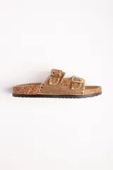 Sandalias bajas color plateado con base de corcho y dos tiras con hebillas ajustables.