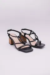 Sandalias de tacón color naranja, con puntera cuadrada, tiras finas con detalle de nudos y tacón geométrico de madera.