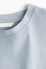 Remera celeste de corte cuadrado, cuello redondo y mangas cortas anchas.