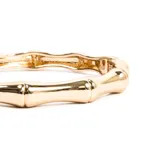 Pulsera rígida dorada con forma de caña de bambú.