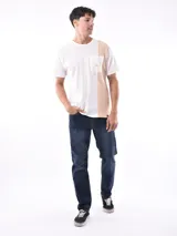 Remera negra de corte oversized con bolsillo en el pecho y detalle de bloque gris en el lateral.