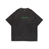 Remera oversize negra con efecto lavado y estampado frontal con el texto "KABOA INDUSTRIES SABOR 100% URUGUAYO" en color verde.