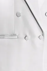 Blazer oversize de satén color blanco, con cuello solapa, escote pico cruzado, manga larga con hombreras, bolsillos de doble vivo y abertura en la espalda. Cierre frontal cruzado con botones forrados.
