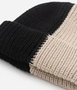 Gorro de lana negro y beige con diseño acanalado y dobladillo.
