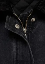Chaqueta oversize de algodón negro con cuello camisero de pana, cierre frontal con cremallera y botones a presión, bolsillos de parche con solapa y bolsillos de ribete.