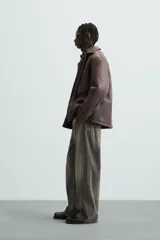 Sobrecamisa marrón de efecto piel con interior de borreguillo a tono, de corte relaxed fit, cuello solapa, manga larga con puños abotonados, bolsillos de plastrón en pecho y laterales, efecto lavado y cierre frontal con botones a presión.