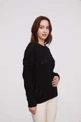 Sweater de punto color mostaza, con diseño de trenzas y puños acampanados.