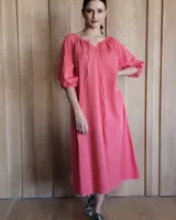 Vestido midi celeste de denim, con escote con lazo, mangas 3/4 abullonadas y corte evasé.