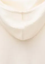 Sweater color crema de tejido de punto fino con cuello alto, manga larga con aberturas para el pulgar y calce ajustado.