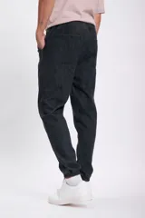 Pantalón jogger de jean color gris oscuro, con cintura elástica y cordón ajustable. Corte holgado con puños elásticos en los tobillos.