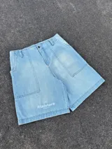 Short de jean celeste con bolsillos delanteros y traseros, y estampado con el logo de la marca en la pierna izquierda.